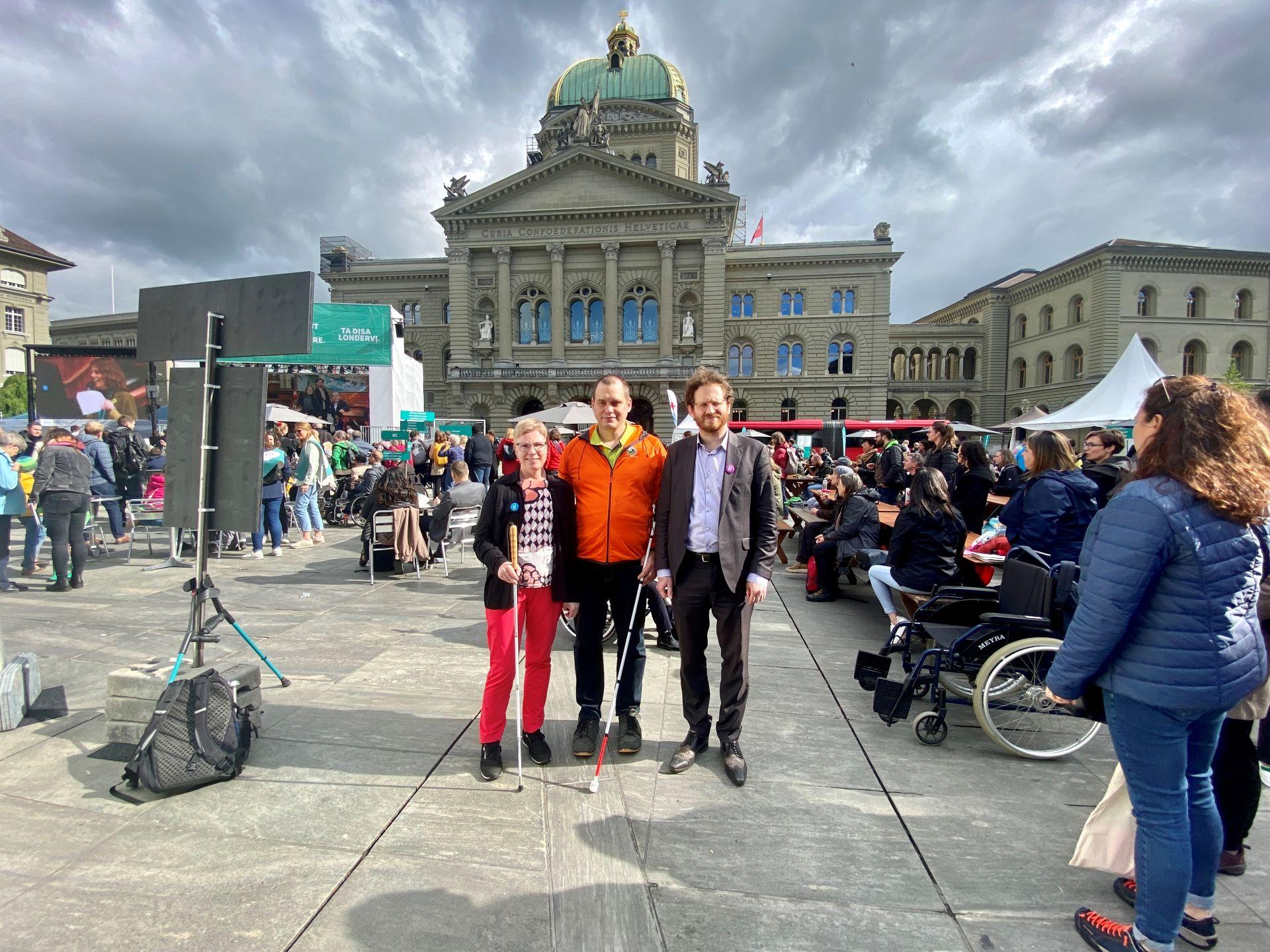Les trois candidats au Conseil national malvoyants Marianne Plüss (Berne), Sébastien Piguet (Vaud) et Cyril Mizrahi (Genève) sont ensemble devant le Palais fédéral.