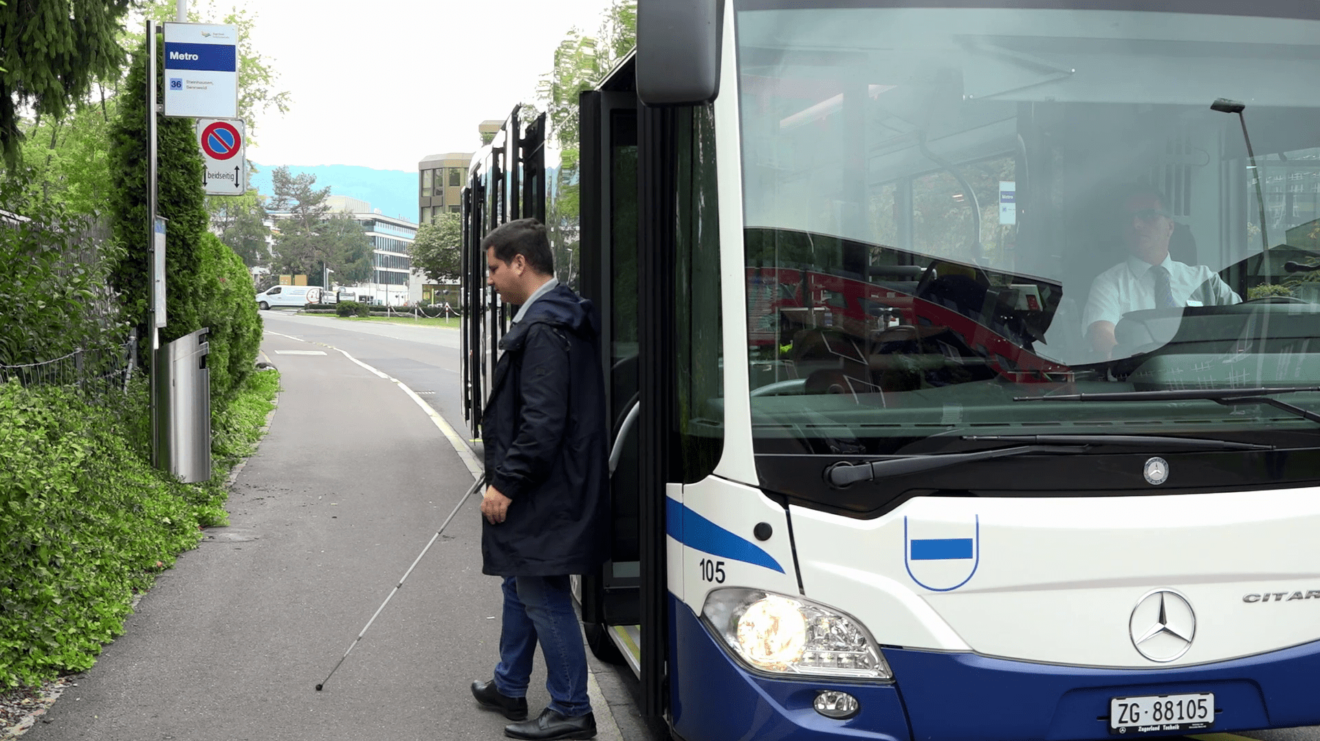Un homme avec une canne blanche descend d'un bus