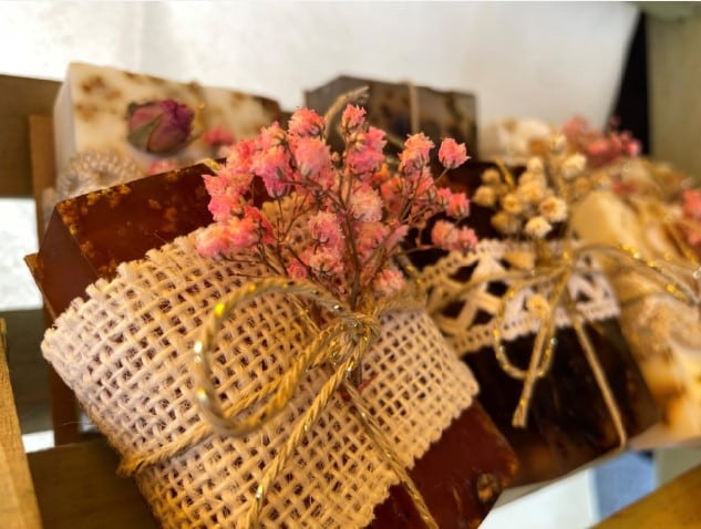 Produkte aus dem BBZ Zürich. Liebevoll mit Trockenblumenschmuck und schönen Textil-Bändern umschnürte Seifen in einem Holzgestell des Frühlingsmarktes.