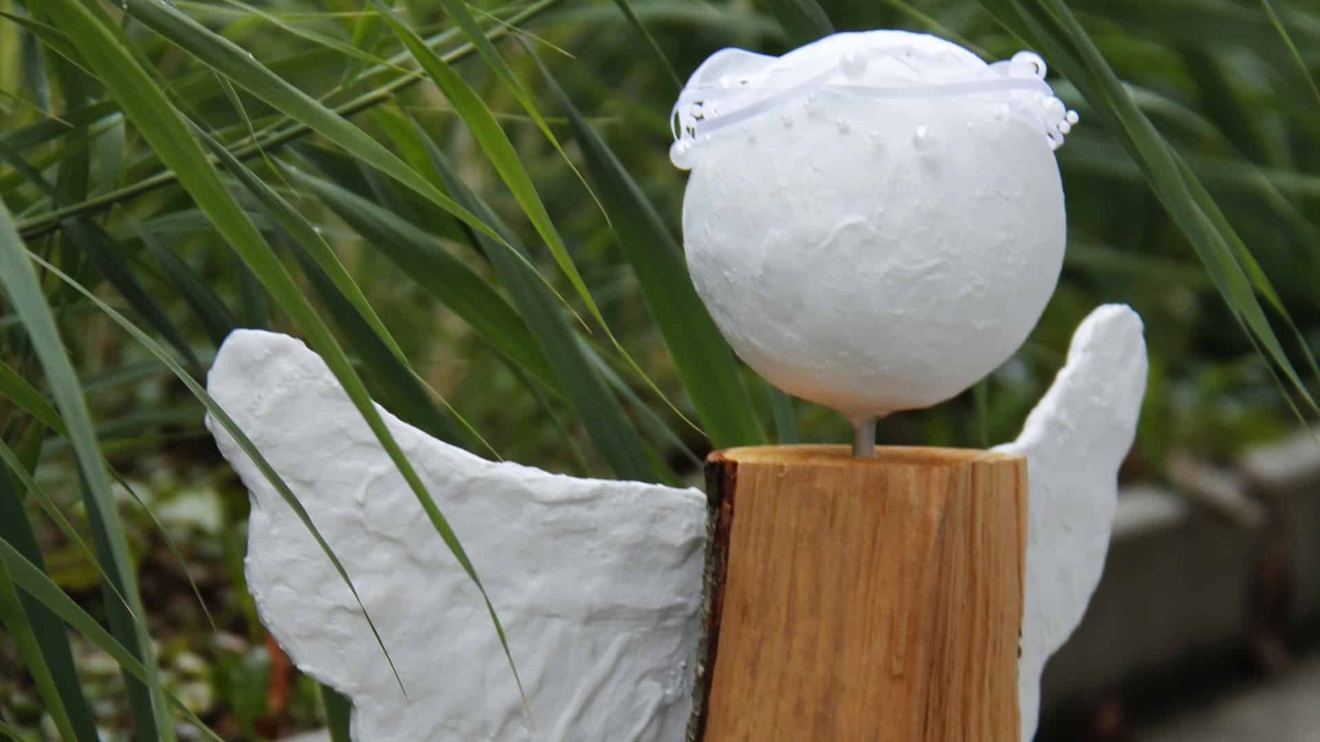 Gros plan: ange bricolé en plâtre et en bois.