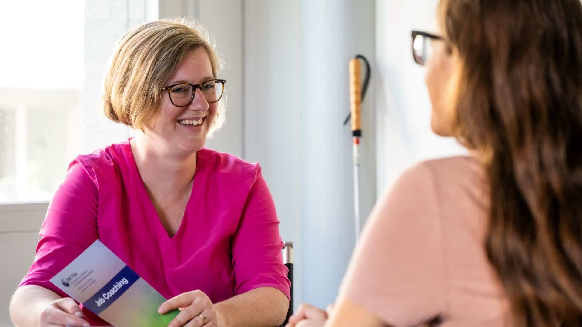 Catherine Rausch, Leiteirn «Job Coaching», berät eine junge Stellensuchende mit Sehbehinderung.