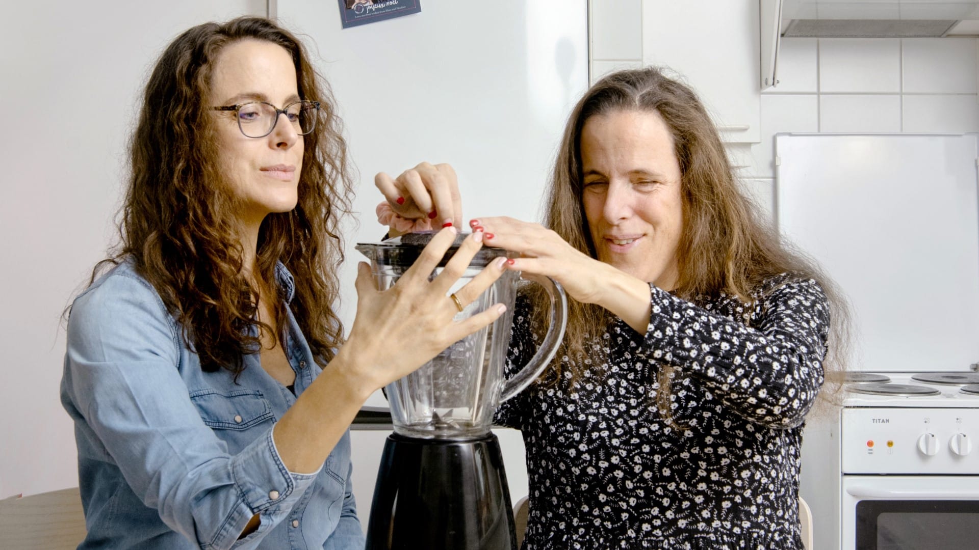 Deux soeurs jumelles explorent un robot ménager. La première fait en sorte qu'il soit stable.