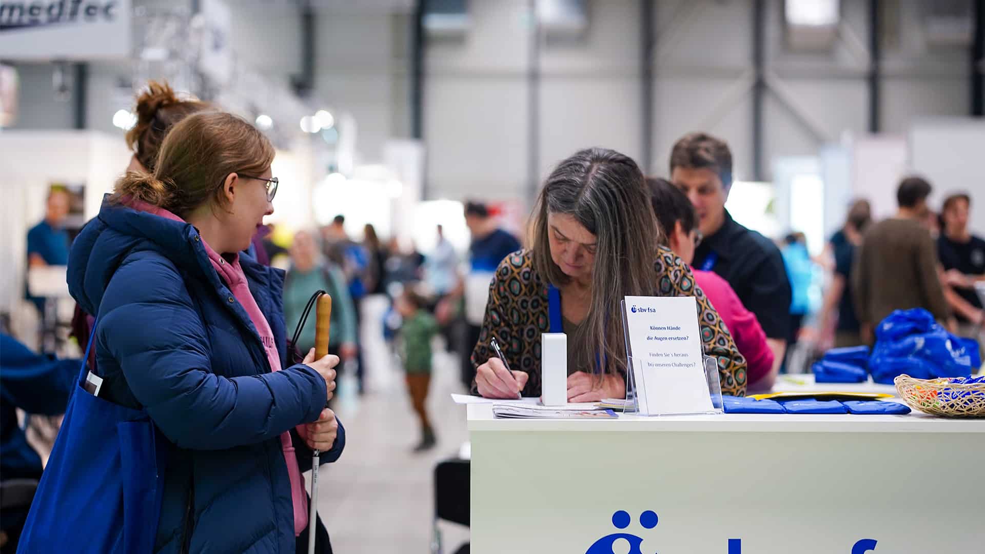 Stand d'information sur un salon avec panneau d'inscription.