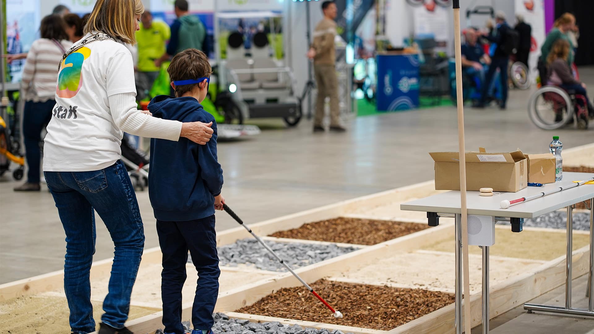 Un enfant s'exerce au maniement d'une canne longue sur une zone interactive du salon.