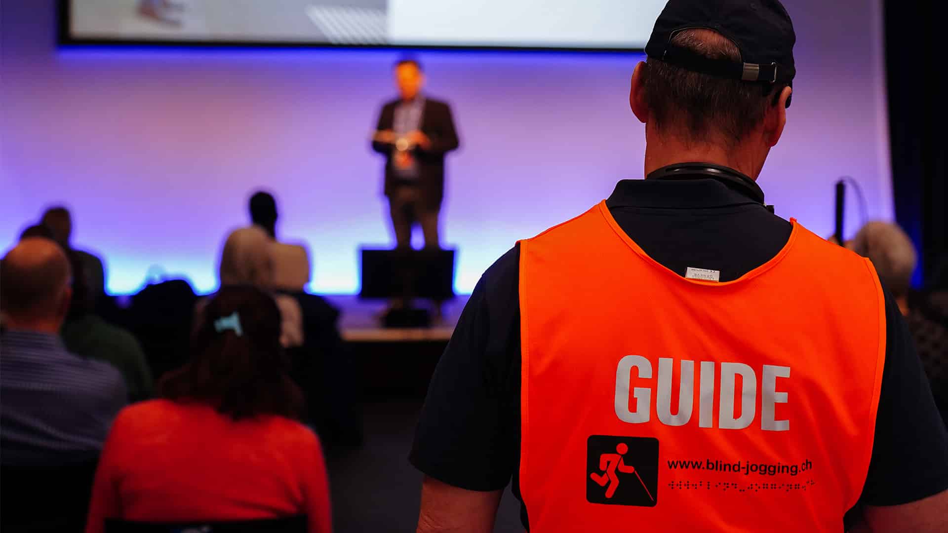 Gros plan sur un gilet de sécurité portant l'inscription « GUIDE » lors d'une table ronde à swissabilities.