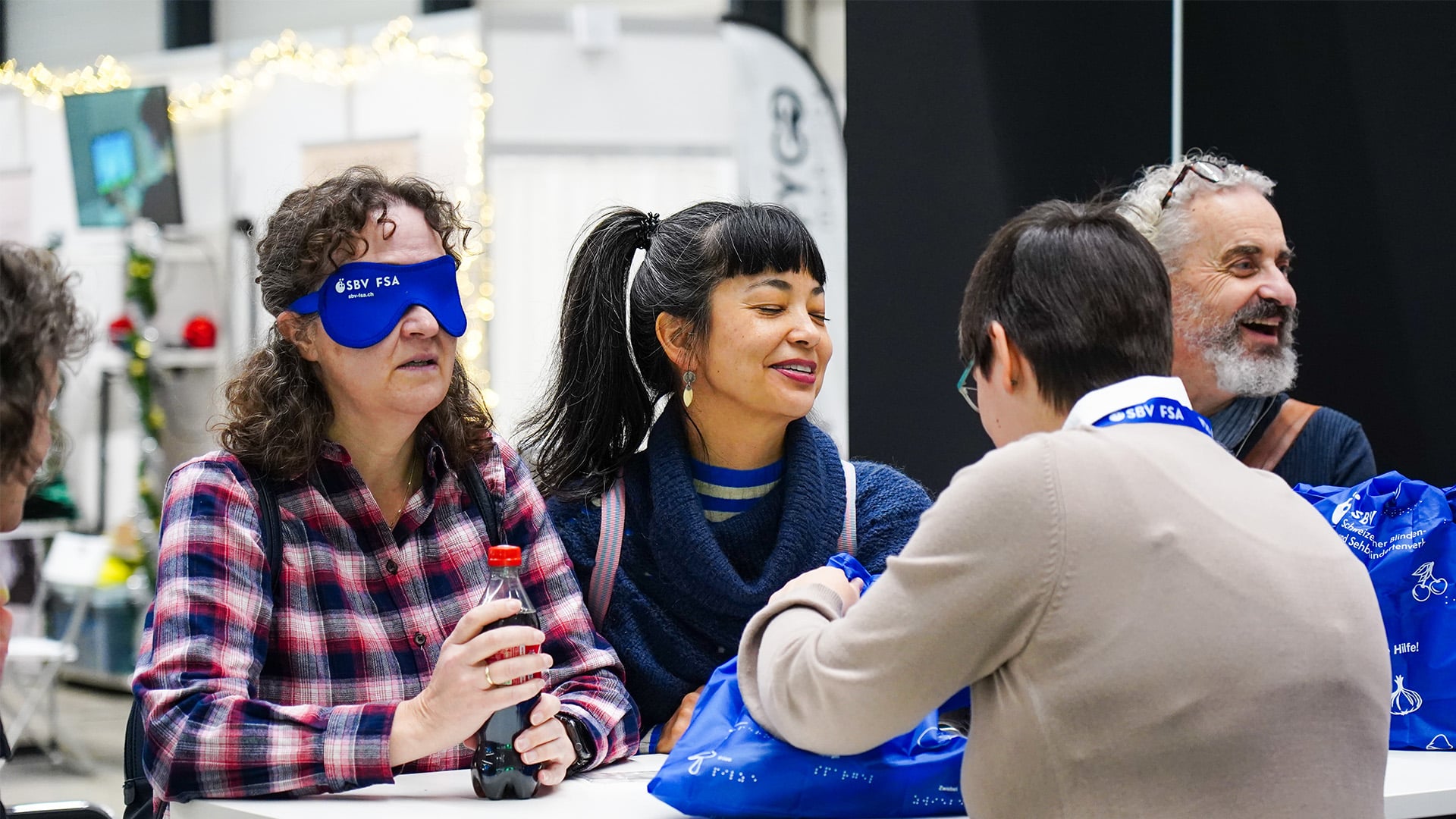 Groupe de personnes aux yeux bandés de bleu au stand de la fsa à swissabilities.