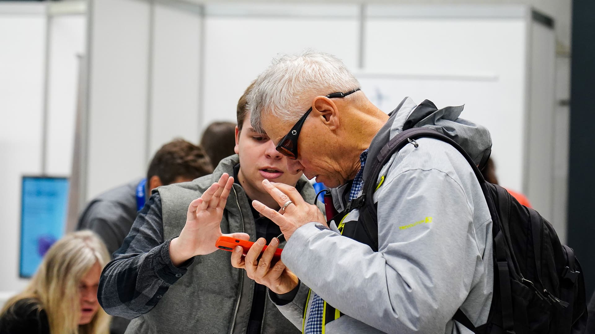 Un homme âgé et un jeune homme discutant de technologie.