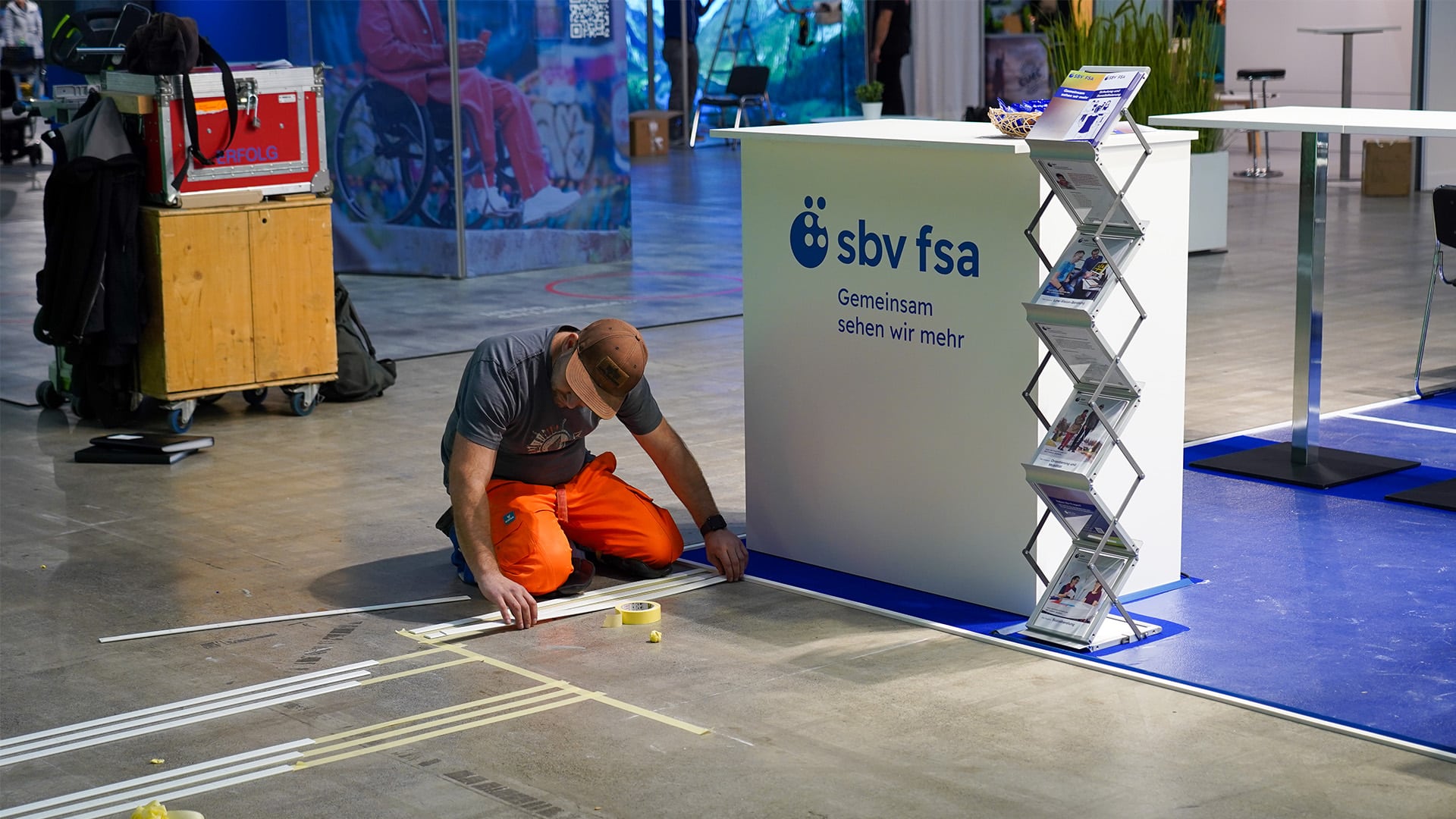 L'artisan marque le sol pour les lignes directrices vers le stand d'exposition.