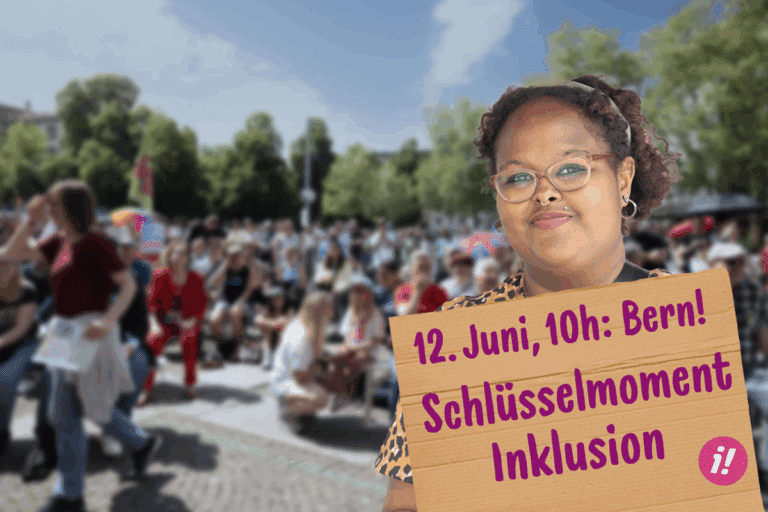 Im Hintergrund ist unscharf eine grosse Menschenmenge anlässlich einer Protestaktion zu erkennen. Vorne rechts im Bild ist eine Frau, die ein Kartonschild in der Hand hält. Auf dem Schild steht in pinker Schrift: 12. Juni, 10 Uhr, Bern- Schlüsselmoment Inklusion. 