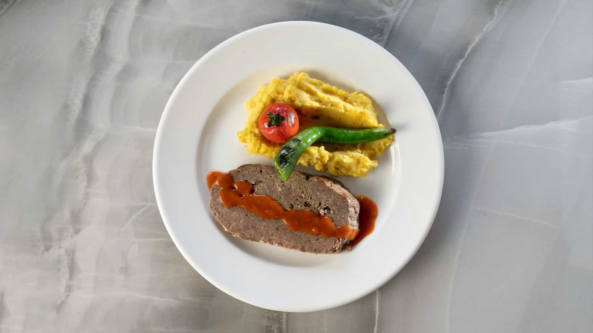 Une assiette avec un morceau de viande et des accompagnements.