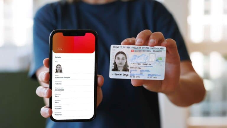 Eine Person hält ein Handy mit der geöffneten E-ID neben der ID.