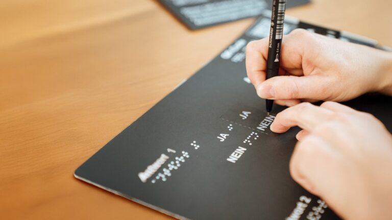 Pochoir de vote, on voit une main avec un stylo qui suit le mot "Nein" sur le modèle d'écriture.