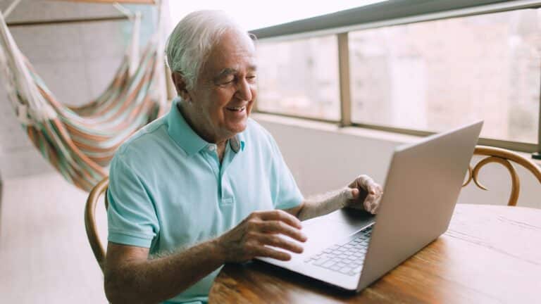 Mann um die 70 am Laptop