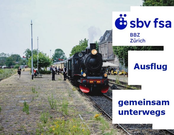 Eine alte Lokomotive setzt in einem alten Bahnhof zur Fahrt an - Leute stehen auf dem grasüberwachsenen Perron.