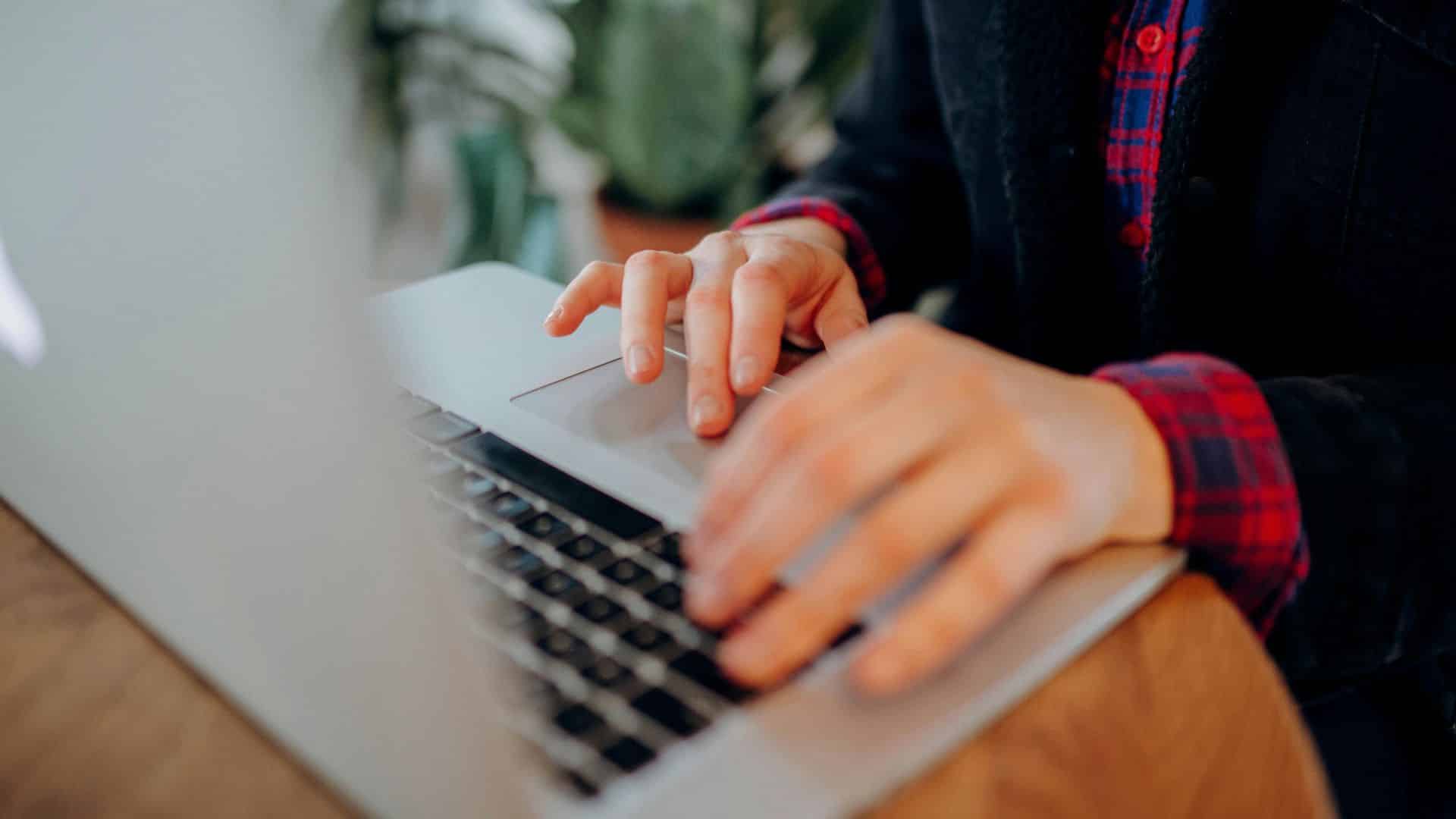 Gros plan de mains sur un clavier d'ordinateur portable