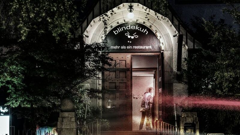 Am Abend ist der Eingang des Restaurants Blindekuh beleuchtet. Über der Tür steht „Blindekuh – mehr als ein Restaurant“.
