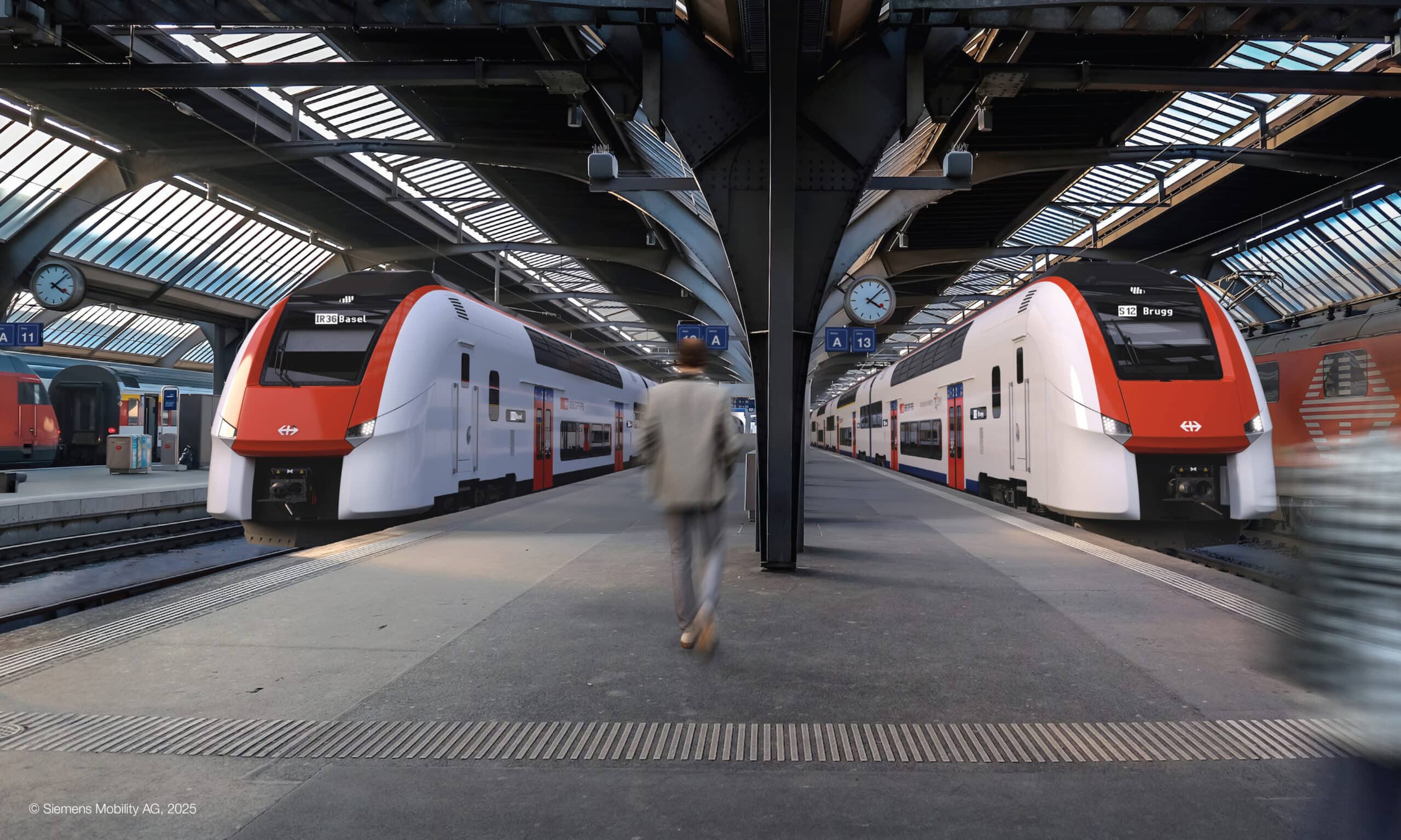 Zwei moderne Doppelstockzüge stehen in einem Bahnhof an gegenüberliegenden Perrons. Auf dem Bahnsteig sind taktile Leitlinien und Sicherheitsmarkierungen für die barrierefreie Orientierung sichtbar. In der Bildmitte bewegt sich ein Mann in einem grauen Anzug über den Bahnsteig. Der Bahnhof ist überdacht, eine Uhr und Schilder mit den Bahngleisen sind sichtbar.