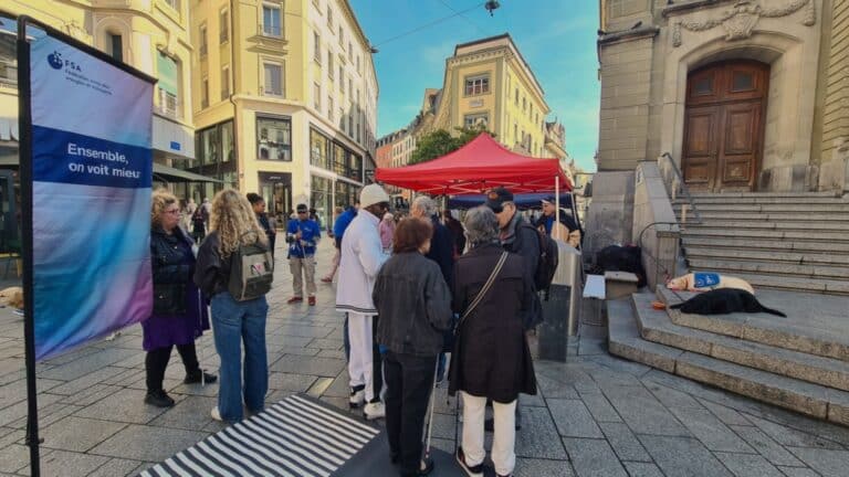 Zahlreiche Leute am Stand des sbv in Lausanne, i, Hintergrund sieht man zwei Blindenführhunde liegen