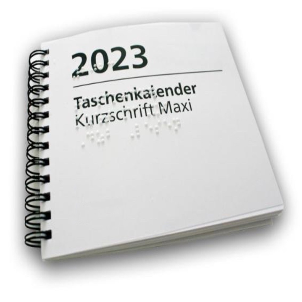BILD: Ein Ringbuchkalender mit der Aufschrift "2023, Taschenkalender, Kurzschrift", welcher zusätzlich mit Braille-Schriftzeichen geprägt ist.