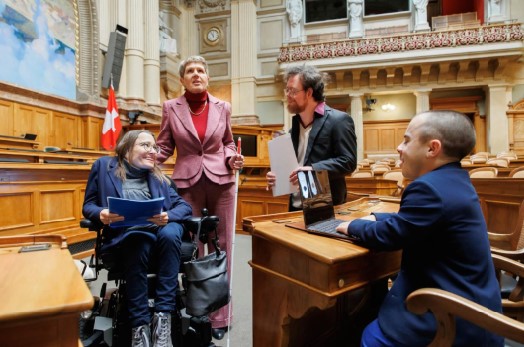BILD: Im Parlamentsgebäude des Bundeshauses unterhalten sich 4 Personen - eine von ihnen sitzt in einem Rollstuhl.