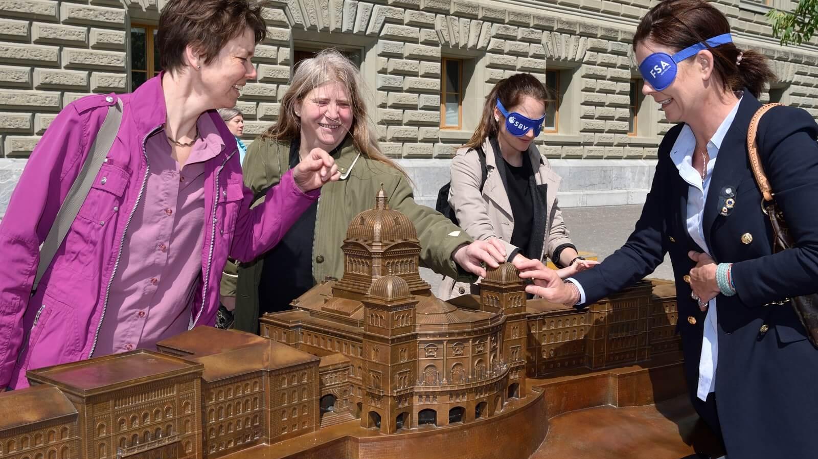 Les visiteurs touchent le modèle du Palais fédéral