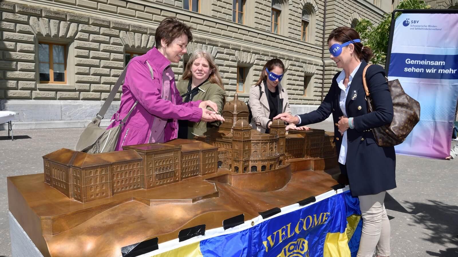 Les visiteurs touchent le modèle du Palais fédéral