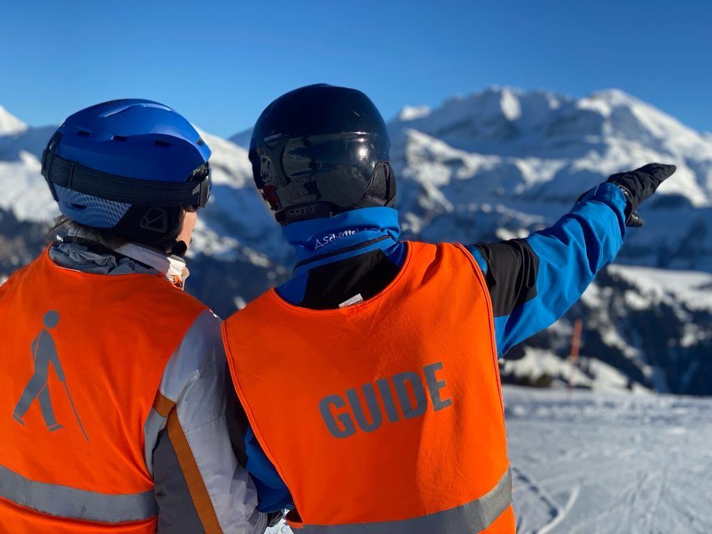 Skifahrerin und Guide vor herrlicher Winterkulisse mit viel Schnee