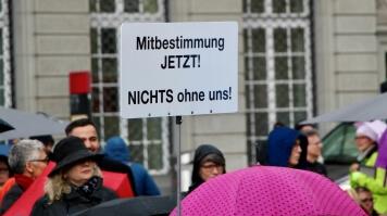 Plusieurs personnes lors d'une manifestation de Pro Infirmis. Une personne tient en l'air une pancarte sur laquelle il est écrit (en allemand) : La participation MAINTENANT ! RIEN sans nous!
