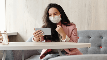 Une femme avec un masque sur son smartphone