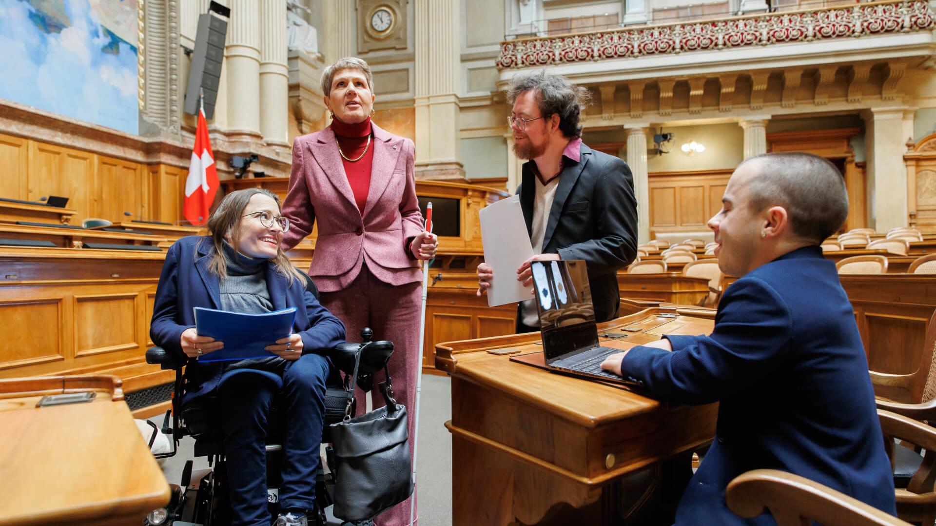 Vier Personen mit einer Behinderung agieren im Bundeshaus.